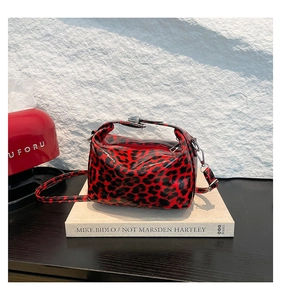 Close-up of red leopard print tote bag with glossy finish and silver zipper detail