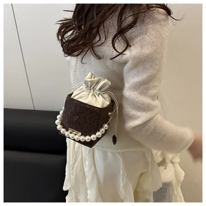 Detail of dark brown snakeskin bucket bag with pearl handle and silk drawstring lining