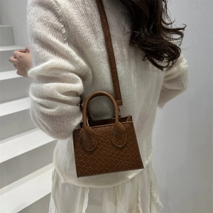 Brown woven texture mini square bag with round handles and crossbody strap