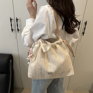 Minimalist beige woven tote bag with lace floral ribbons and leather shoulder strap