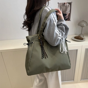 Olive green large capacity tote bag with drawstring details and striped rope ornament