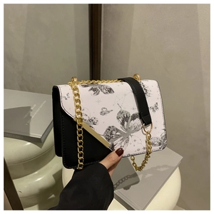 Détail du sac à bandoulière avec imprimé papillon étoile, chaîne dorée et cuir noir