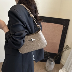 Sac sous le bras en cuir tressé beige avec étoile argentée et poignée nouée