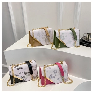 Détail de quatre sacs carrés à imprimé papillon avec finitions en V dorées et chaînes