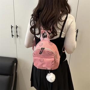 Mini-Rucksack aus rosa Cord mit schwarzen Smiley-Mustern und weißem Bommel-Anhänger