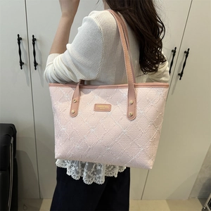 Pink tote bag with white bow embroidery and gold metal logo plaque for daily commute