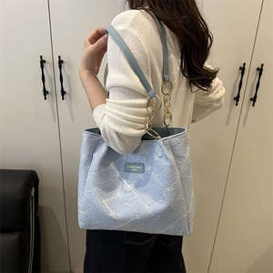 Sac cabas bleu clair avec broderie florale blanche et bandoulière en chaîne dorée
