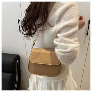 Detail of camel leather saddle bag with woven texture and Fashion & Bags Leather text