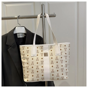 Détail du sac cabas blanc avec motif d'ours et plaque logo en métal poli