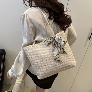 Minimalist straw tote bag with herringbone weave and decorative scarf for summer vacation