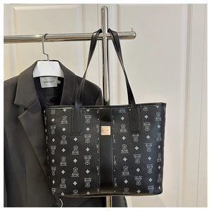 Détail du sac cabas noir avec imprimé ours suspendu avec une veste blazer