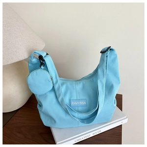 Dettaglio della borsa hobo a mezzaluna azzurra con tessuto a coste e mini portamonete