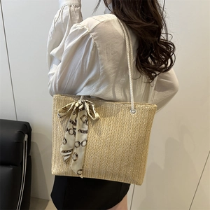 Large straw tote bag with woven chevron pattern and stylish silk scarf accessory