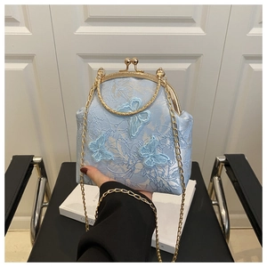 Détail du sac coquille bleu clair avec broderie papillon 3D et cadre doré élégant