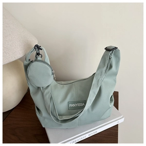 Dettaglio della borsa hobo a mezzaluna in velluto verde con piccolo portamonete tondo