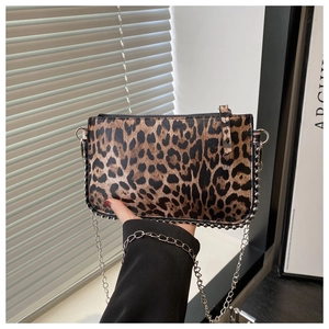 Detail view of leopard print crossbody bag with metallic studs and chain strap