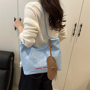 Light blue denim tote bag with cute dog embroidery and stylish charm in a modern room