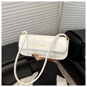 Detail of white patent leather shoulder bag with gold logo and metallic buckles