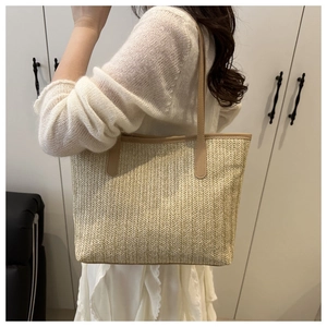 Detailed macro view of woven straw texture and premium beige leather shoulder straps