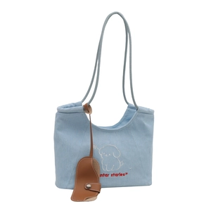 Light blue denim tote bag with white puppy embroidery and a brown leather charm accessory