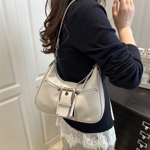 Minimalist cream white crescent shoulder bag with metallic buckle shown on model