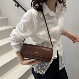 Borsa baguette minimalista in pelle testa di moro con scritte dorate sulla spalla