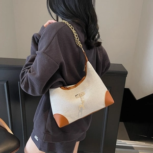 Women's chic beige fabric underarm bag with brown leather trim and golden deer charm