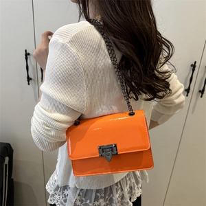 Sac bandoulière en cuir verni orange brillant avec fermoir à clous pyramides