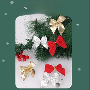 Nahaufnahme von Weihnachtsbaum-Schleifen in Gold, Silber und Rot auf festlichen Zweigen