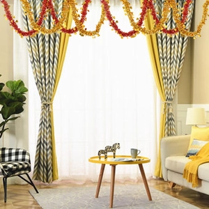 Red and gold tinsel garland with heart accents hanging in a modern living room