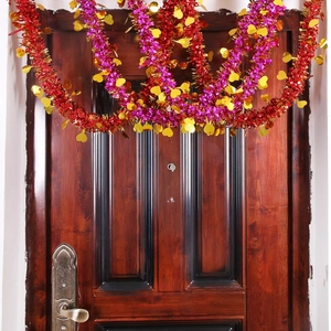 Red pink and gold heart-shaped foil tinsel garland hanging on a wooden door frame decoration