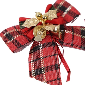 Close-up of red plaid Christmas bow with golden bells and leaves for tree decoration
