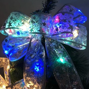 Detail einer silbernen Weihnachtsschleife mit bunten LED-Lichtern und Sternenmuster