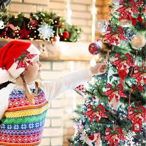 Child hanging a red Christmas bow with gold bell on a decorated tree, merry festive scene