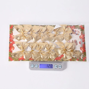 Detailed view of 12 gold Christmas tree bow ornaments in packaging on a scale