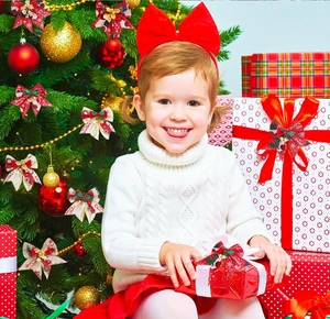 Detail of Christmas plaid bows with gold bells held by a child for tree decoration