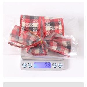 Detailed view of 9.3g weight measurement for a red and black plaid Christmas bow ornament