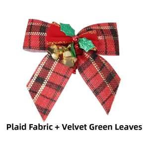Close-up of red plaid burlap Christmas bow with green leaves, berries and gold bells