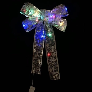 Nahaufnahme einer leuchtenden Weihnachtsschleife mit bunten LEDs und Sternmustern