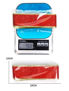 Close-up of 2M sparkling red glitter ribbon with gold edges in roll packaging