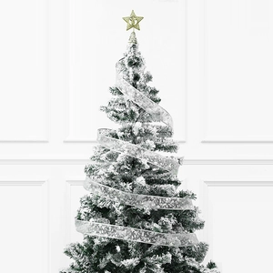 Detail eines silbernen Schneeflockenbandes um einen beflockten Weihnachtsbaum mit Goldstern