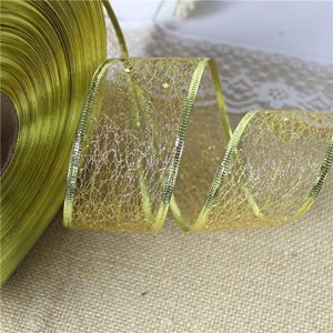 Close-up of golden mesh ribbon with sequins and metallic edges for gift wrapping