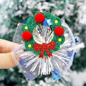 Détail de pince à cheveux couronne de Noël avec nœud rouge, paillettes et tulle blanc