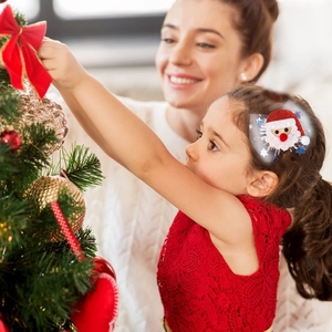 Close-up of a child wearing a Santa Claus hair clip with mesh and sequins for Christmas