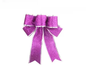 Macro view of purple glitter Christmas bow with silver trim and handmade texture