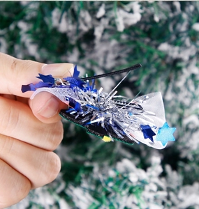 Detailed shot of Christmas star hair clip with blue sequins, lace, and silver tassels