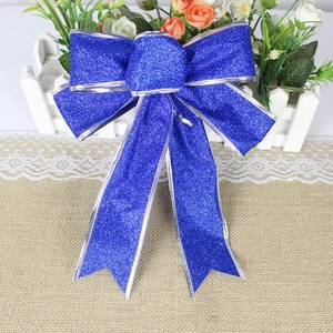 Close-up of royal blue glitter Christmas bow with silver wire edges for holiday decor