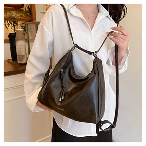 Close-up of a dark brown PU leather tote with adjustable strap and front zipper detail