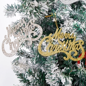 Close-up of glittery Merry Christmas hanging signs on a snow-dusted festive tree