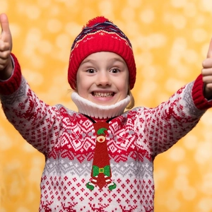 Detail of red Christmas felt tie for kids featuring glittery elf shoes and green belt buckle